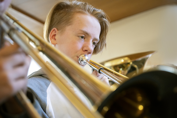 Young teenage boy playing the trombone